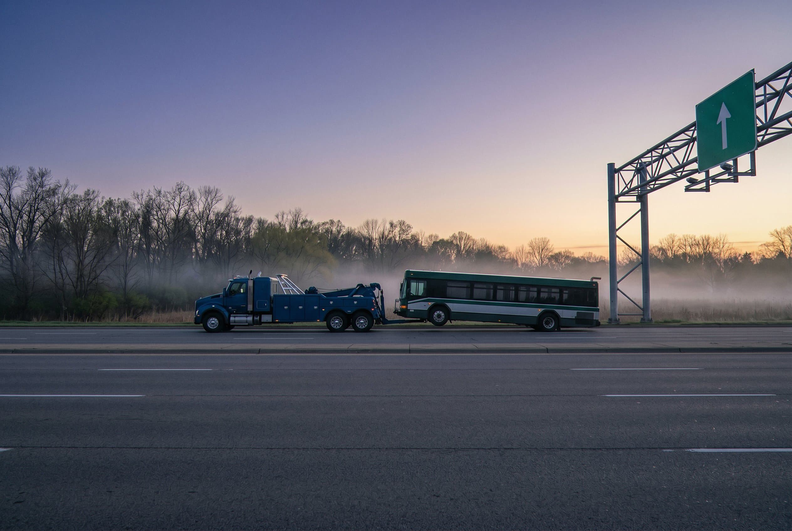 Heavy wrecker lifting bus highway